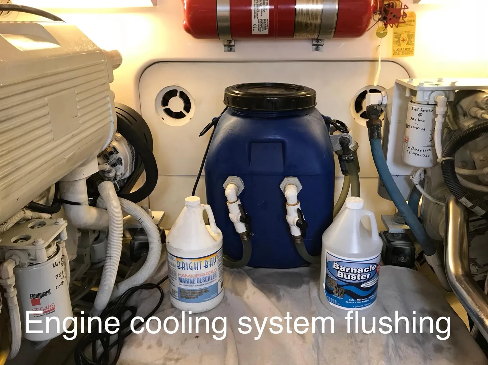 Engine cooling system flush in progress with coolant containers connected to a marine diesel