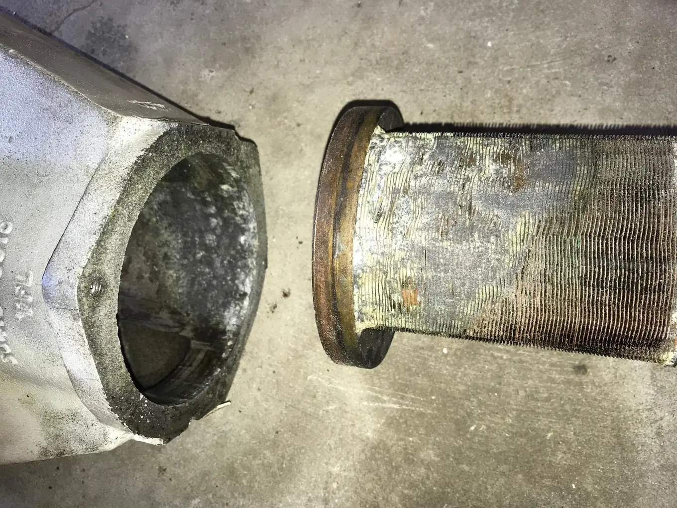 Sectioned marine exhaust component showing severe internal corrosion